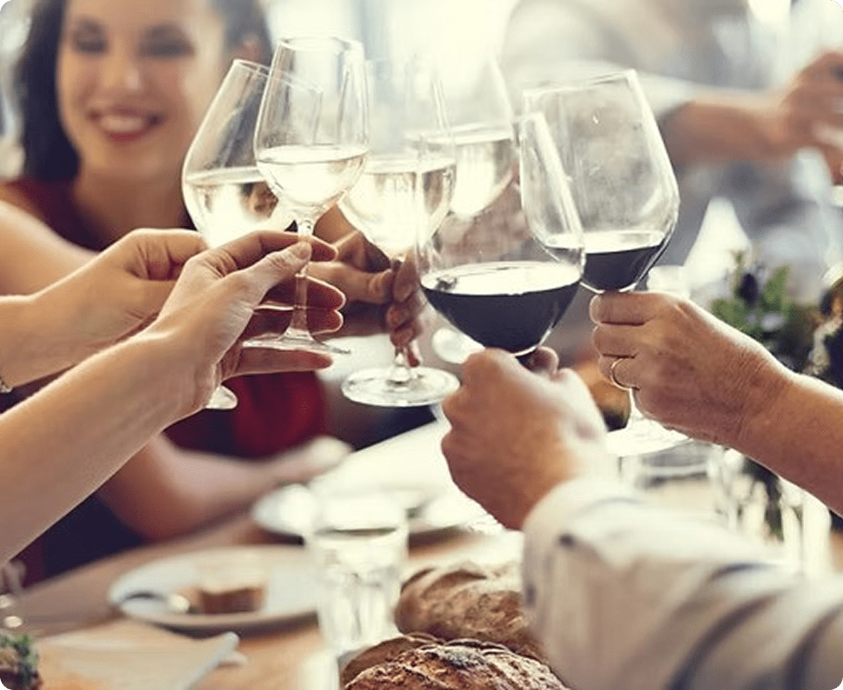 People clinking wine glasses at dinner
