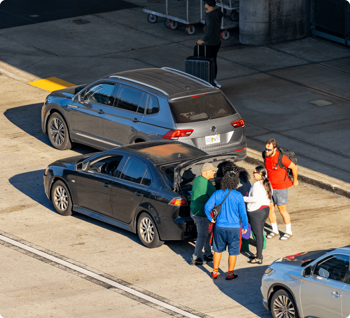 People gathering around parked cars at airport