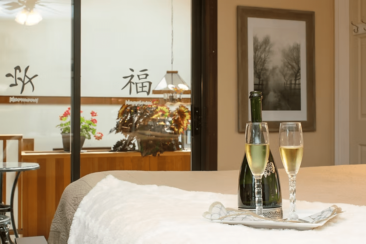Champagne and glasses on cozy bed