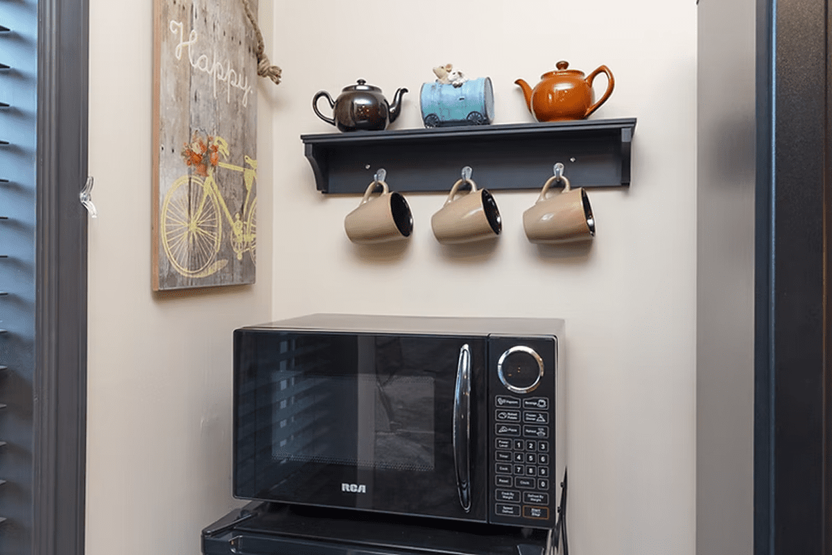 Kitchen shelf with mugs and microwave